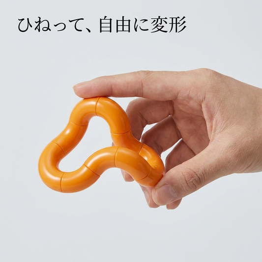 オレンジのねじねじフィジェットを手でひねって変形させる様子