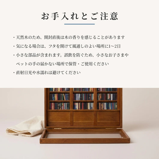 お手入れとご注意のカード。柔らかい布を添えた、開いた状態のミニチュア本棚の静物写真。