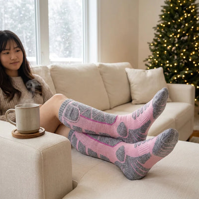 ピンクのヒーターソックスを履いてソファでくつろぐ女性