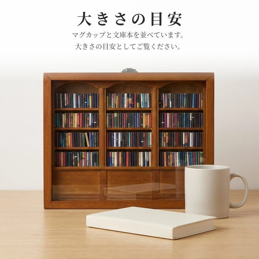 無地のマグカップと文庫本サイズの本を横に並べた、大きさ比較のカット。目盛りや数字は入れず、並べて比べるだけ。