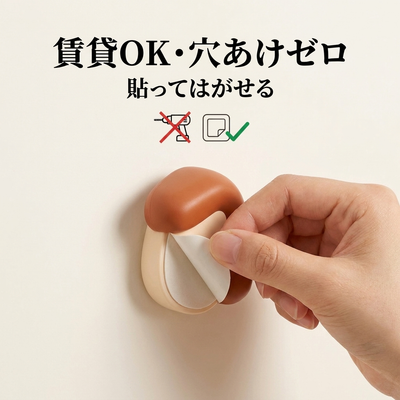 賃貸OK・穴あけゼロ。貼ってはがせる粘着ボタンを壁からはがす様子。