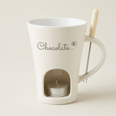 ミルキーホワイトのマグ、前面に濃いグレーの「Chocolate…」プリント、右側の取っ手、底のキャンドル窓とフォーク付き