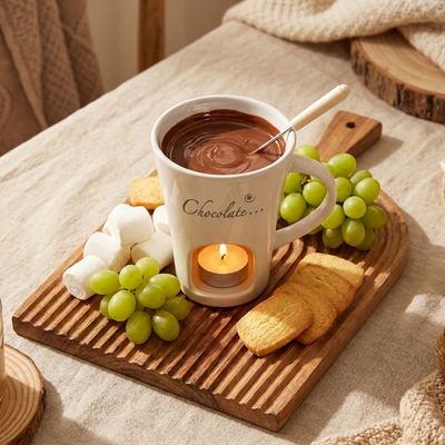 ホワイトのマグ（前面に「Chocolate…」プリント）ととろけチョコを中心にブドウ・マシュマロ・ビスケットを木のボードに並べた俯瞰