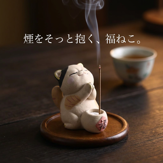煙をそっと抱く福ねこ