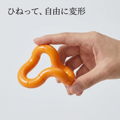 オレンジのねじねじフィジェットを手でひねって変形させる様子